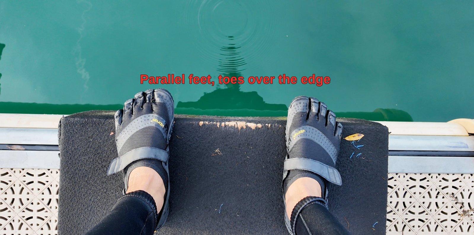 Parallel feet with toes over the edge of the start box